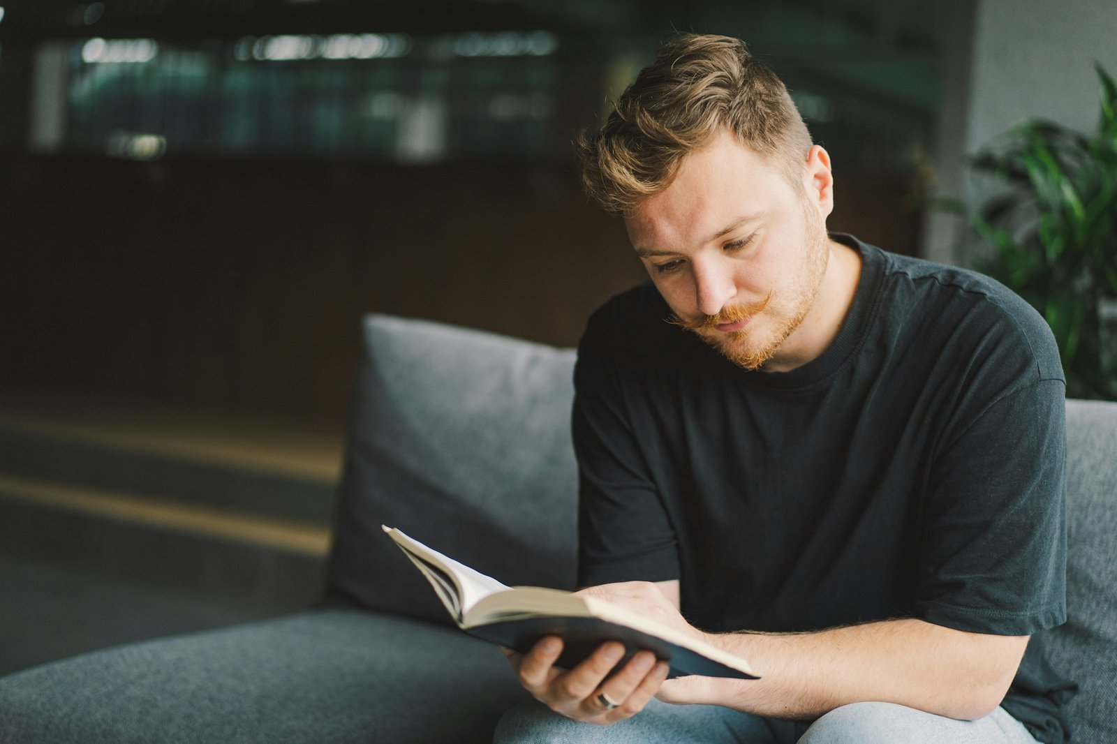 Christian man holds holy bible in hands. Reading the Holy Bible in a home.